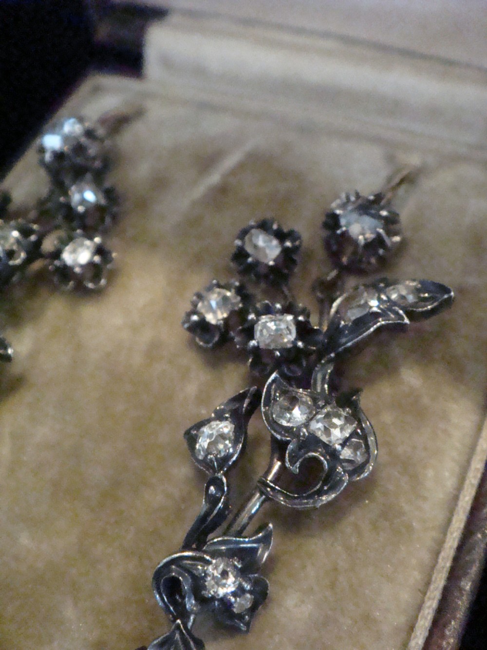 A pair of antique yellow gold and silver drop earrings featuring foliate diamond sprays and natural pearl drops presented inside a velvet box. View III