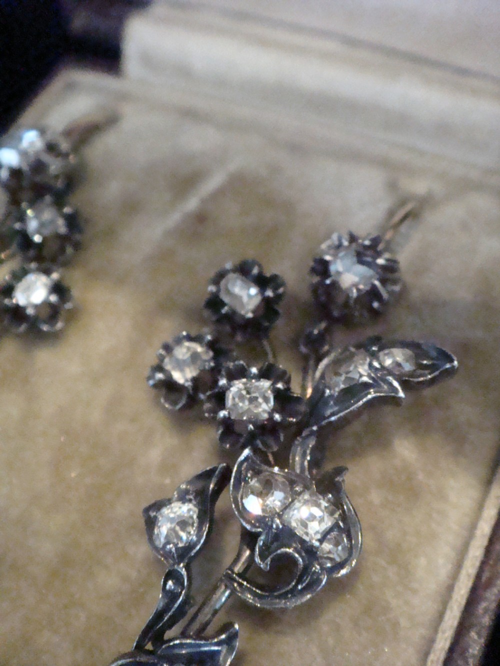 A pair of antique yellow gold and silver drop earrings featuring foliate diamond sprays and natural pearl drops presented inside a velvet box. View IV