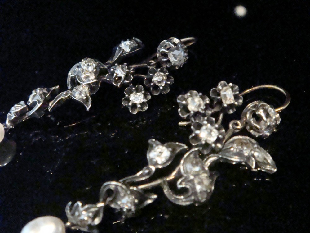 A pair of antique yellow gold and silver drop earrings featuring foliate diamond sprays and natural pearl drops presented inside a velvet box. View VIII