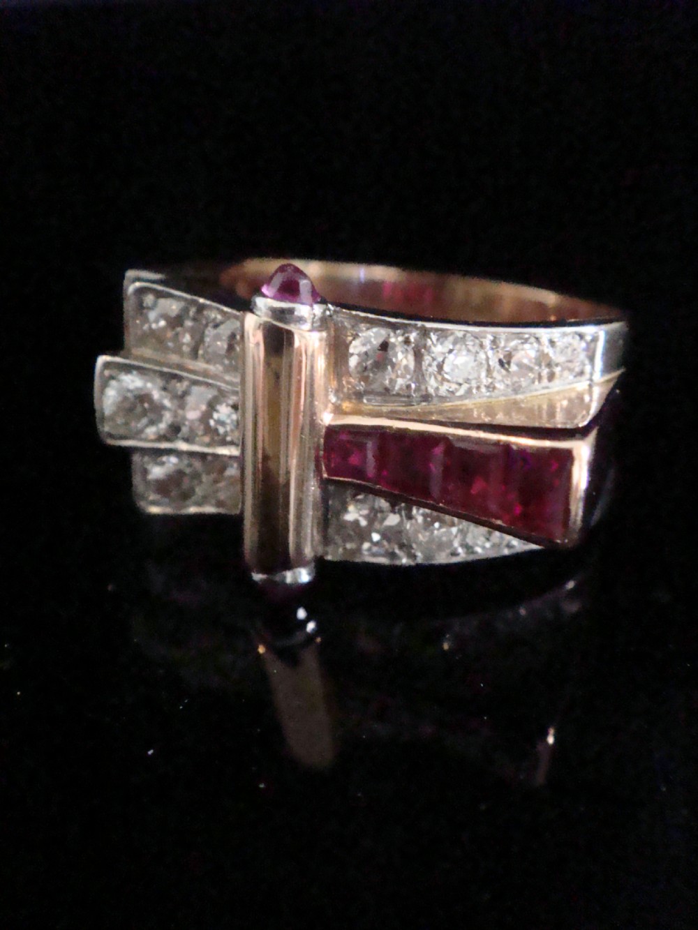 An 18ct gold Retro Modern tank ring featuring geometric diamond shoulders and a channel of calibre-cut red rubies. View III