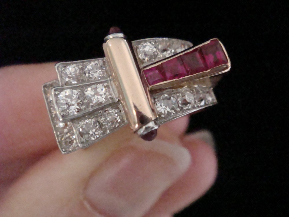 An 18ct gold Retro Modern tank ring featuring geometric diamond shoulders and a channel of calibre-cut red rubies. View VIII
