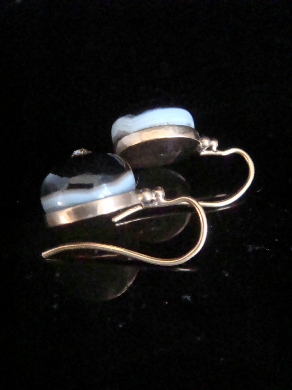 A pair of spherical black agate drop earrings mounted in 9ct yellow gold with a single small diamond set in the centre of each stone. View III