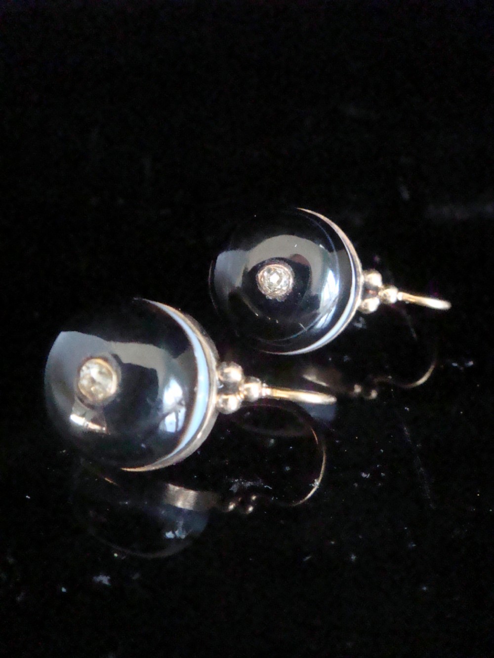 A pair of spherical black agate drop earrings mounted in 9ct yellow gold with a single small diamond set in the centre of each stone. View II