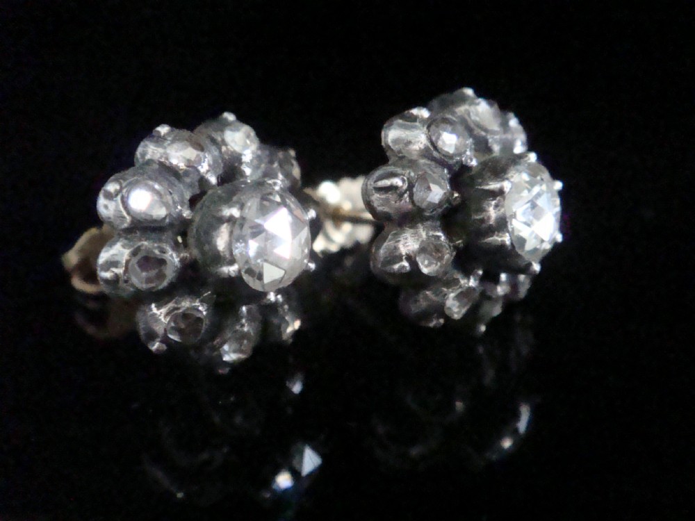 A pair of Victorian 18ct gold stud earrings featuring rose cut diamonds arranged in a floral cluster halo pattern.
