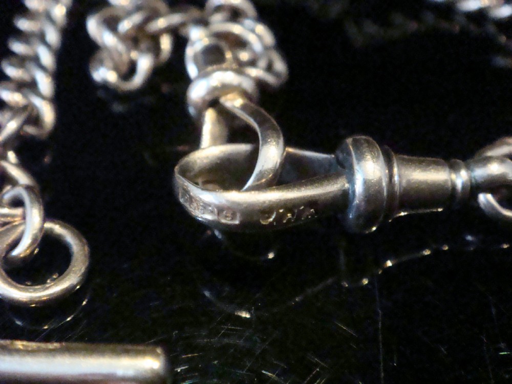 An Edwardian 9ct rose gold curb-link Albert chain featuring double dog clips and a central T-bar. View III