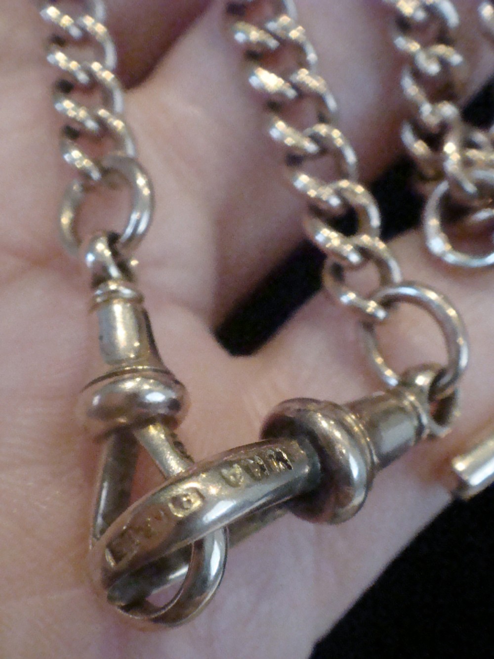 An Edwardian 9ct rose gold curb-link Albert chain featuring double dog clips and a central T-bar. View IV