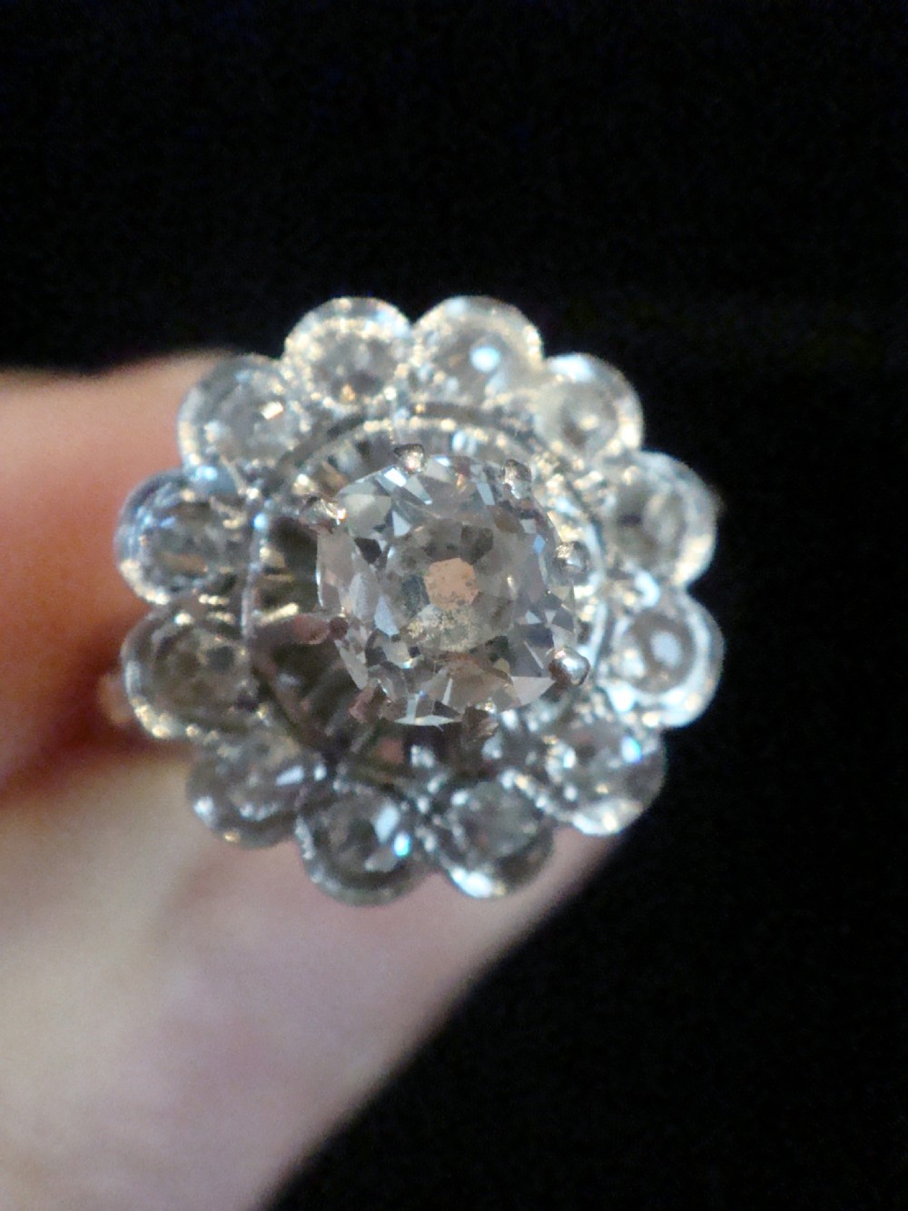 An Edwardian 18ct yellow gold cluster ring set with a central old-cut diamond surrounded by a floral halo of smaller old-cut diamonds. View II