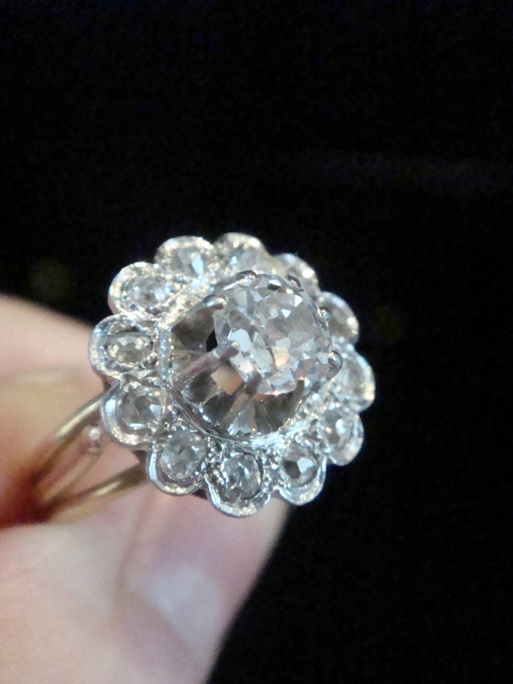 An Edwardian 18ct yellow gold cluster ring set with a central old-cut diamond surrounded by a floral halo of smaller old-cut diamonds. View III