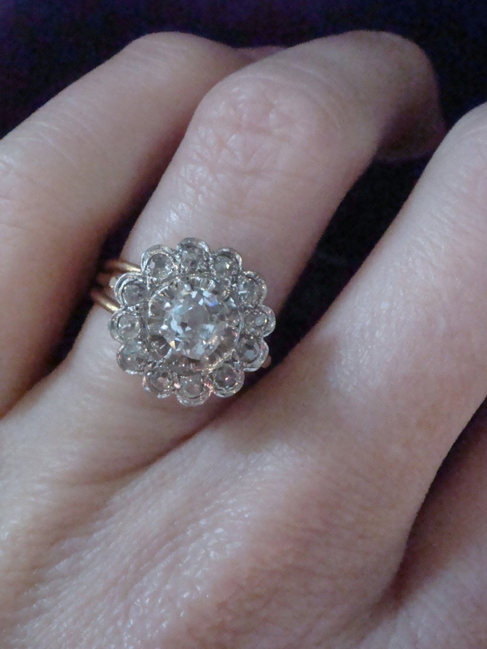 An Edwardian 18ct yellow gold cluster ring set with a central old-cut diamond surrounded by a floral halo of smaller old-cut diamonds. View VII