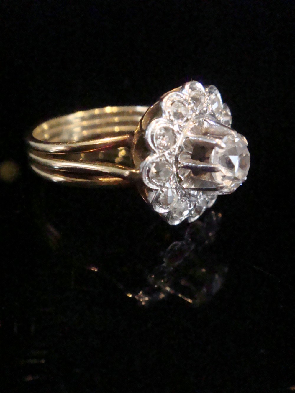 An Edwardian 18ct yellow gold cluster ring set with a central old-cut diamond surrounded by a floral halo of smaller old-cut diamonds. View VIII