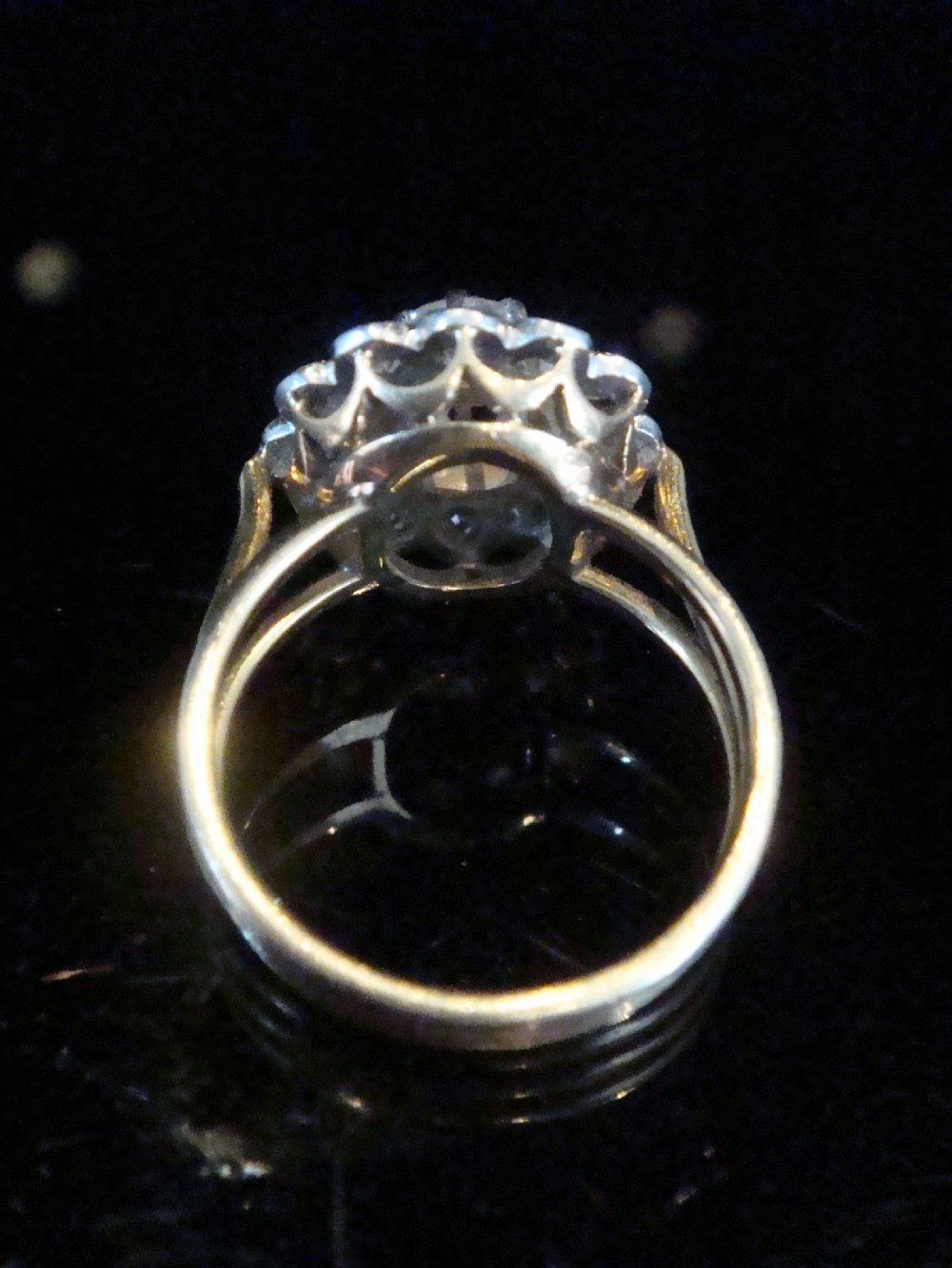 An Edwardian 18ct yellow gold cluster ring set with a central old-cut diamond surrounded by a floral halo of smaller old-cut diamonds. View IX