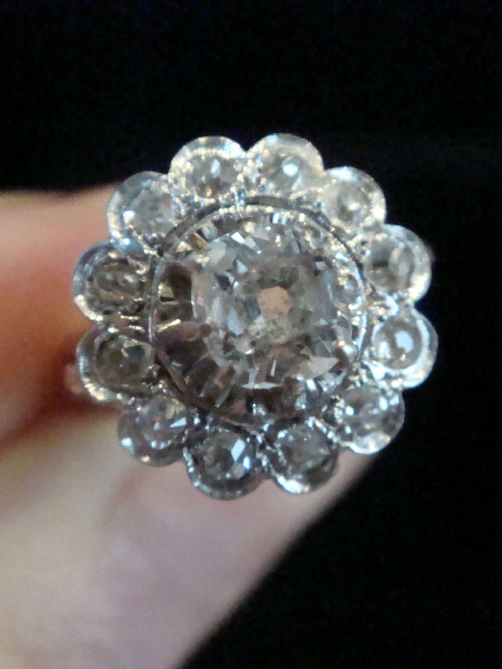 An Edwardian 18ct yellow gold cluster ring set with a central old-cut diamond surrounded by a floral halo of smaller old-cut diamonds. View X