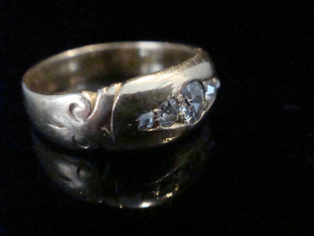 An Edwardian 18ct yellow gold band ring featuring flush-set old cut diamonds along the centre. View VI