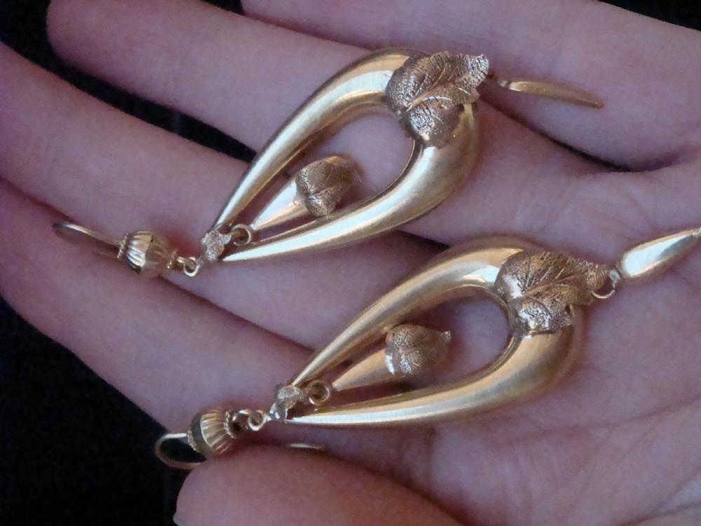 A pair of Victorian 9ct yellow gold drop earrings featuring open teardrop frames embellished with detailed leaf motifs and hanging lower drops. View III