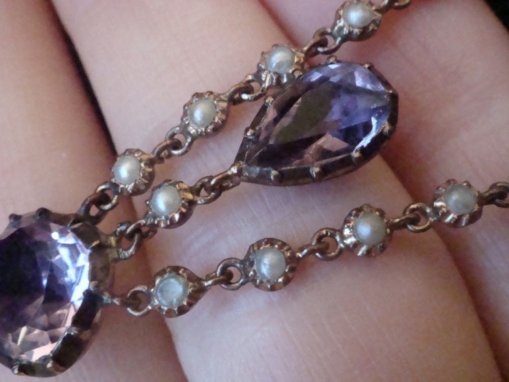 An early Victorian yellow gold lavalier pendant necklace featuring oval and teardrop cut purple amethysts bordered with natural pearls. View V