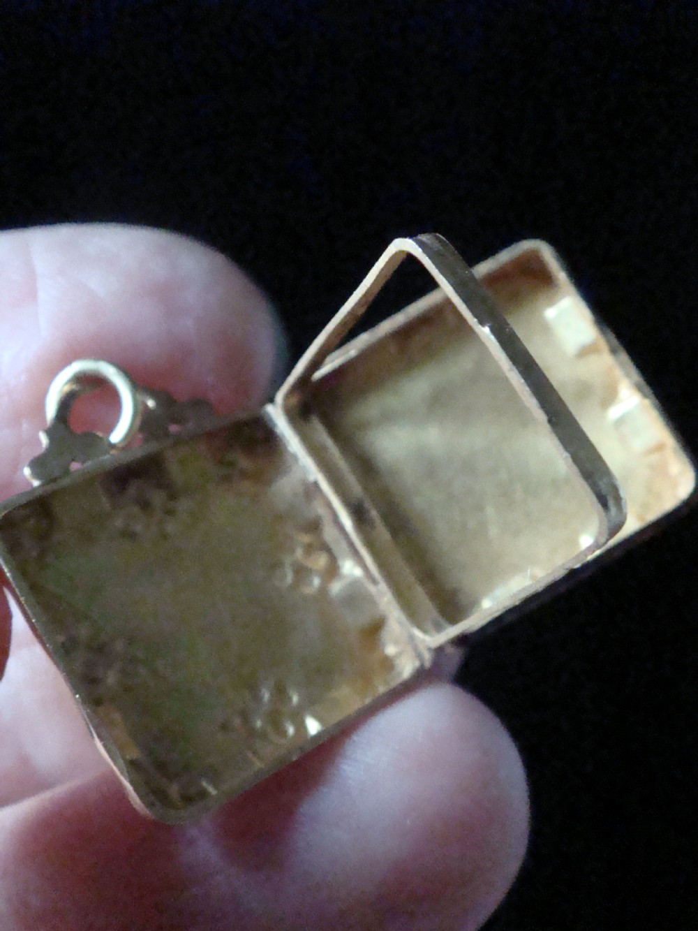 An Edwardian square yellow gold book locket with engraved floral and geometric motifs. View II