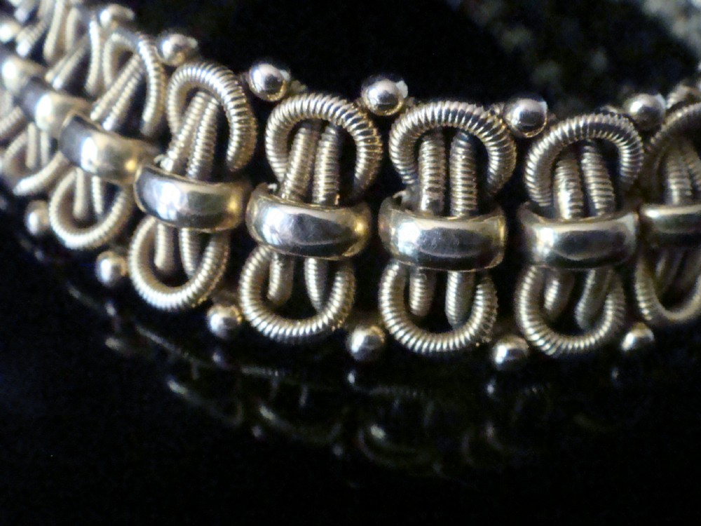 An Edwardian 18ct yellow gold bracelet featuring intricate interlocking wirework links and granulated bead detailing. View II