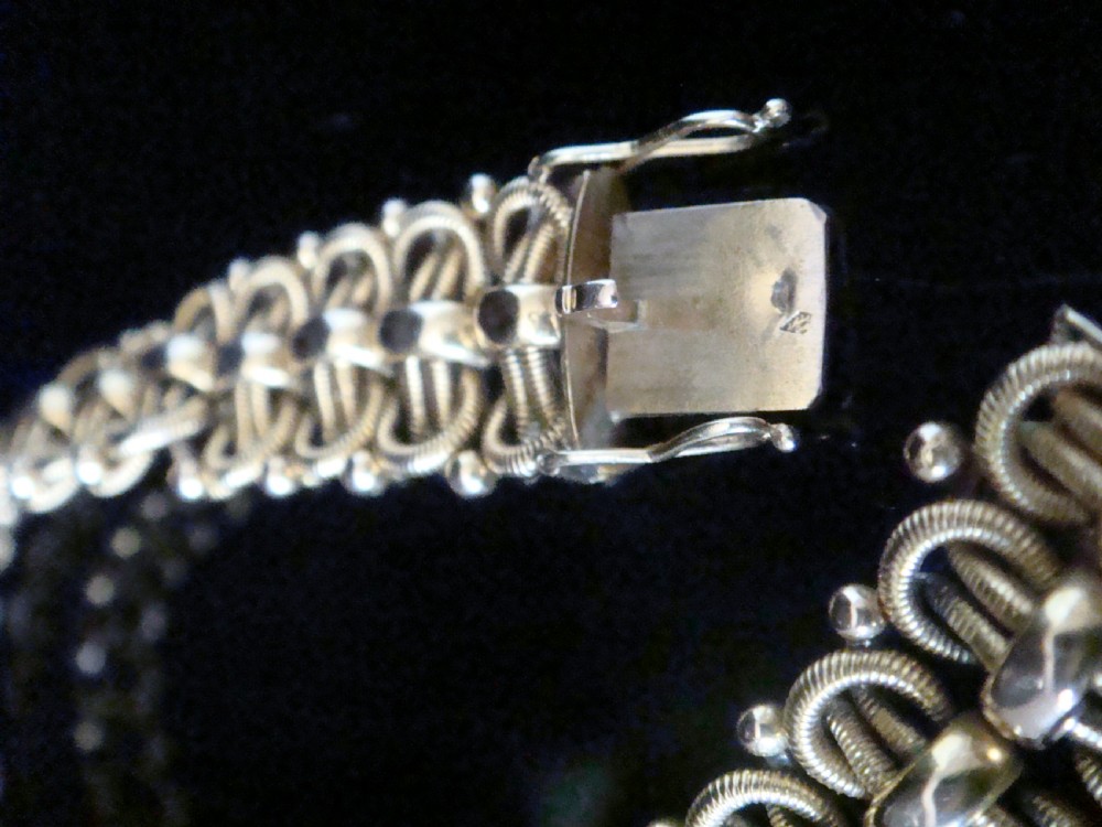 An Edwardian 18ct yellow gold bracelet featuring intricate interlocking wirework links and granulated bead detailing. View IV