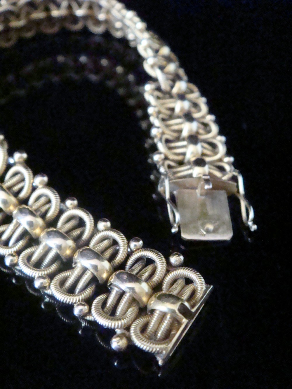 An Edwardian 18ct yellow gold bracelet featuring intricate interlocking wirework links and granulated bead detailing. View VIII