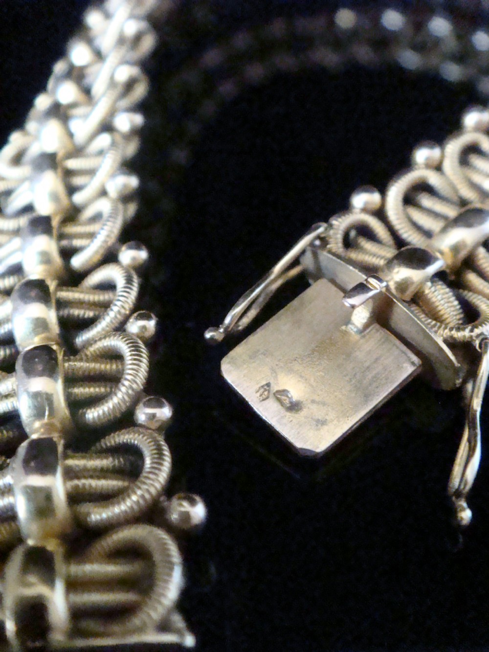 An Edwardian 18ct yellow gold bracelet featuring intricate interlocking wirework links and granulated bead detailing. View IX