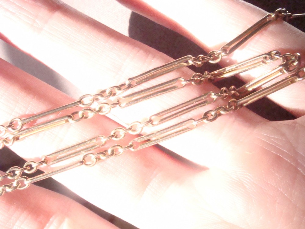 An Edwardian 9ct gold trombone link chain featuring elongated cylindrical links connected by circular jump rings. View II