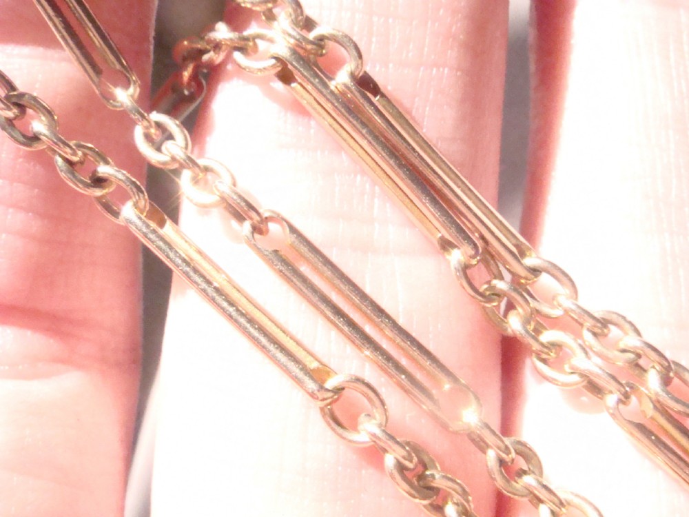 An Edwardian 9ct gold trombone link chain featuring elongated cylindrical links connected by circular jump rings. View III