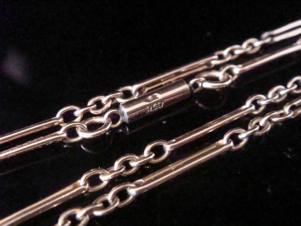 An Edwardian 9ct gold trombone link chain featuring elongated cylindrical links connected by circular jump rings. View IV