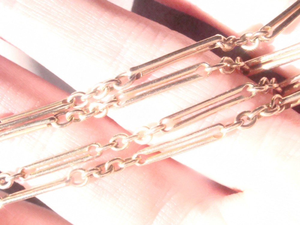 An Edwardian 9ct gold trombone link chain featuring elongated cylindrical links connected by circular jump rings. View VI