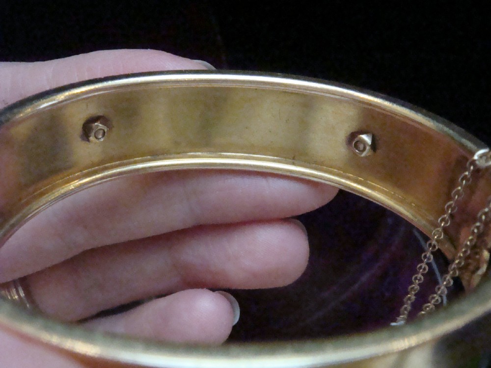 An antique 18ct gold cuff bracelet set with a central row of seed pearls framed by beaded borders, shown inside a velvet presentation box. View VIII