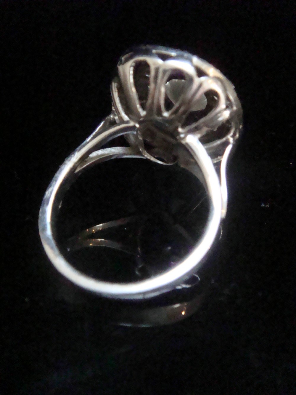 An Edwardian 18ct white gold target cluster ring set with a central old cut diamond surrounded by concentric tiers of diamonds and fine millegrain details. View III