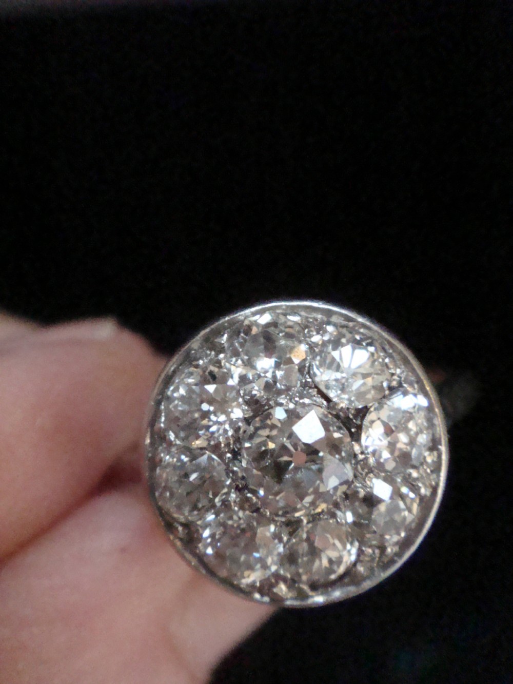 An Edwardian 18ct white gold ring featuring a circular cluster set with natural old cut diamonds. View II