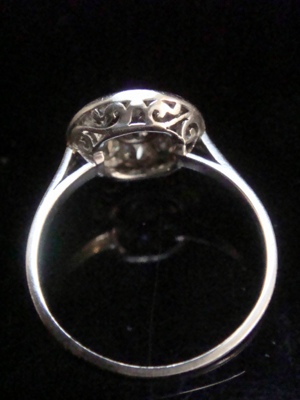 An Edwardian 18ct white gold ring featuring a circular cluster set with natural old cut diamonds. View VI