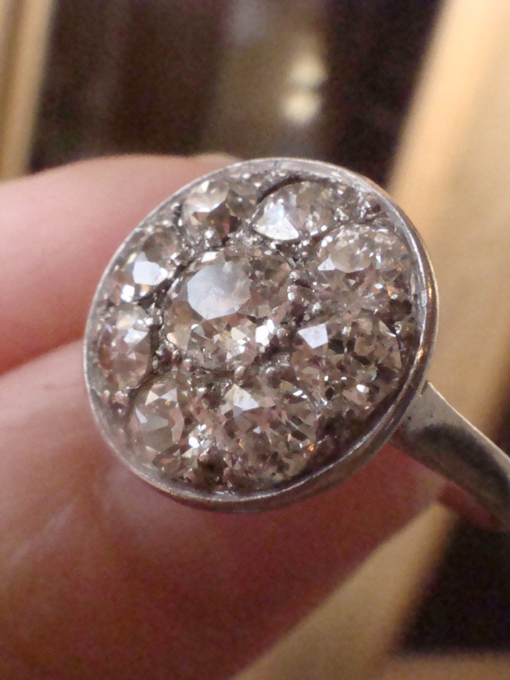 An Edwardian 18ct white gold ring featuring a circular cluster set with natural old cut diamonds. View IX
