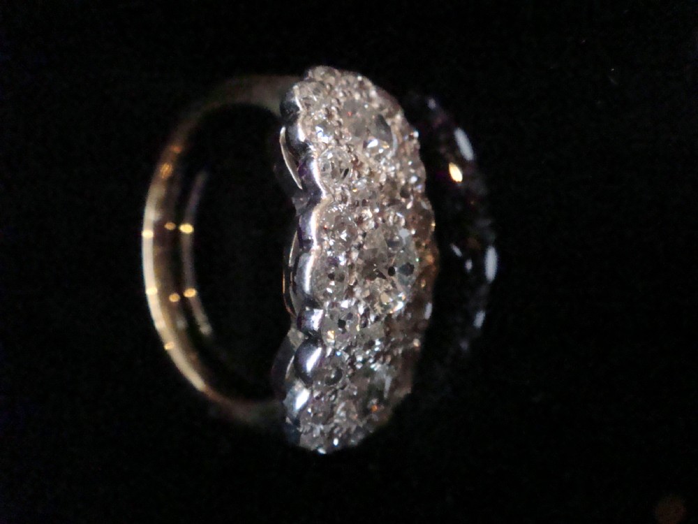 An Edwardian 18ct yellow gold and platinum cluster ring set with multiple natural old cut diamonds in an oval layout. View II