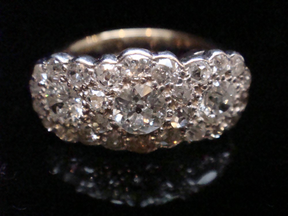 An Edwardian 18ct yellow gold and platinum cluster ring set with multiple natural old cut diamonds in an oval layout. View V