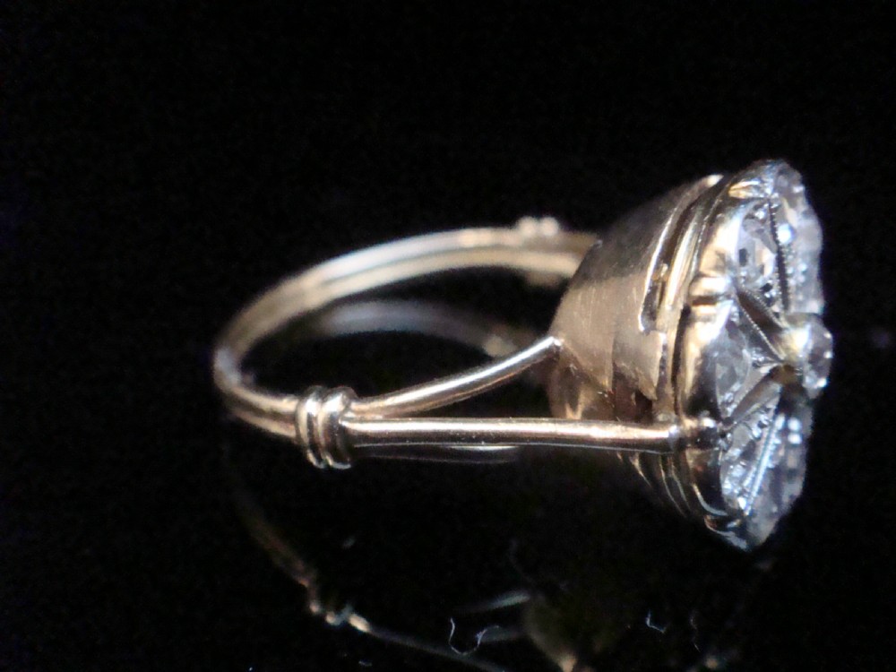An Edwardian 18ct yellow gold and platinum ring featuring a floral starburst cluster set with old-cut diamonds. View II