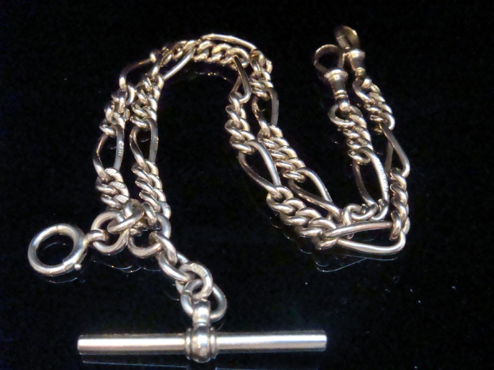 An Edwardian 9ct yellow gold Figaro link double Albert chain featuring a central T-bar, floating ring, and two dog clip fasteners.