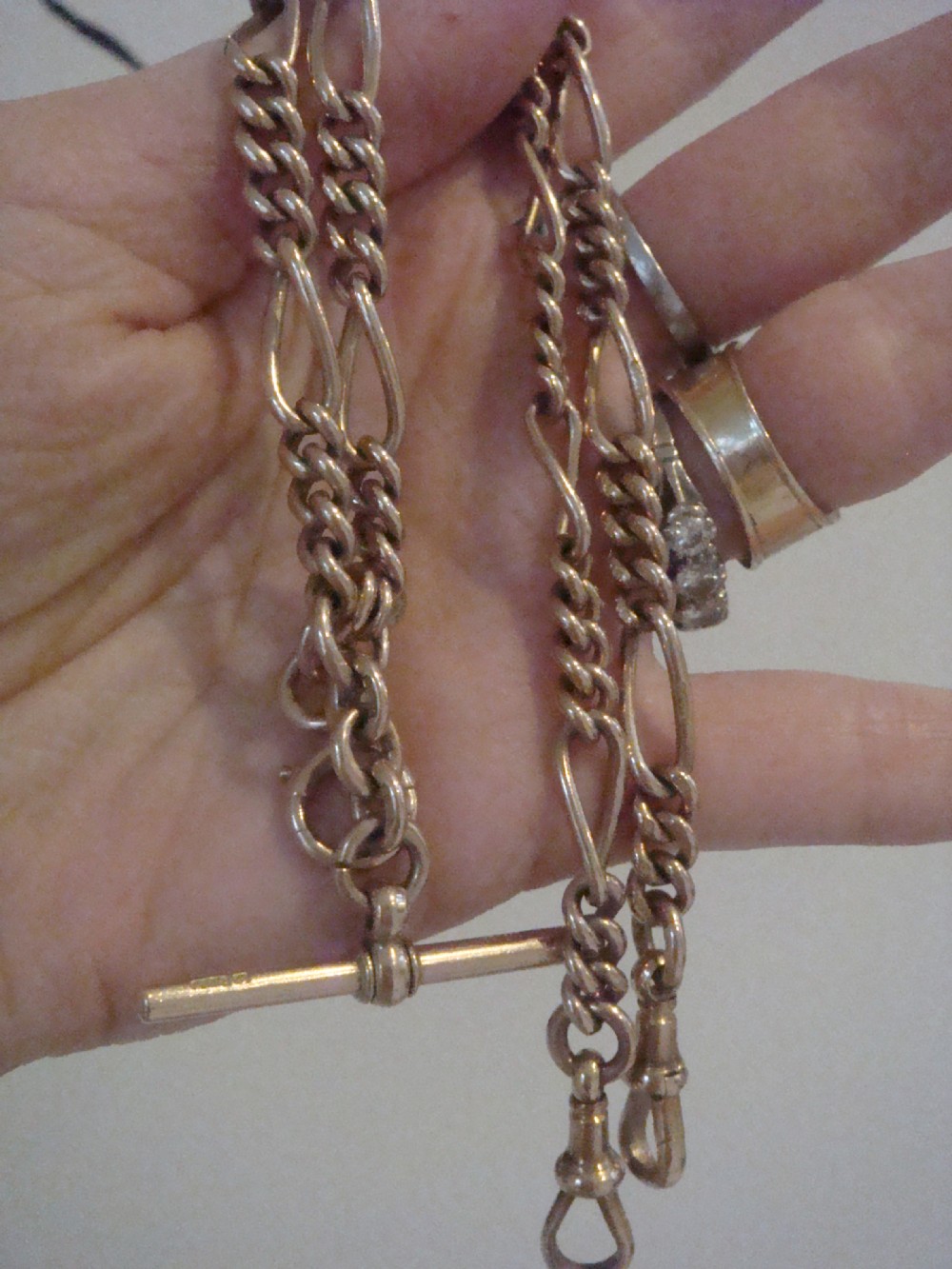 An Edwardian 9ct yellow gold Figaro link double Albert chain featuring a central T-bar, floating ring, and two dog clip fasteners. View II