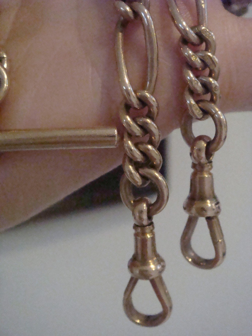 An Edwardian 9ct yellow gold Figaro link double Albert chain featuring a central T-bar, floating ring, and two dog clip fasteners. View III
