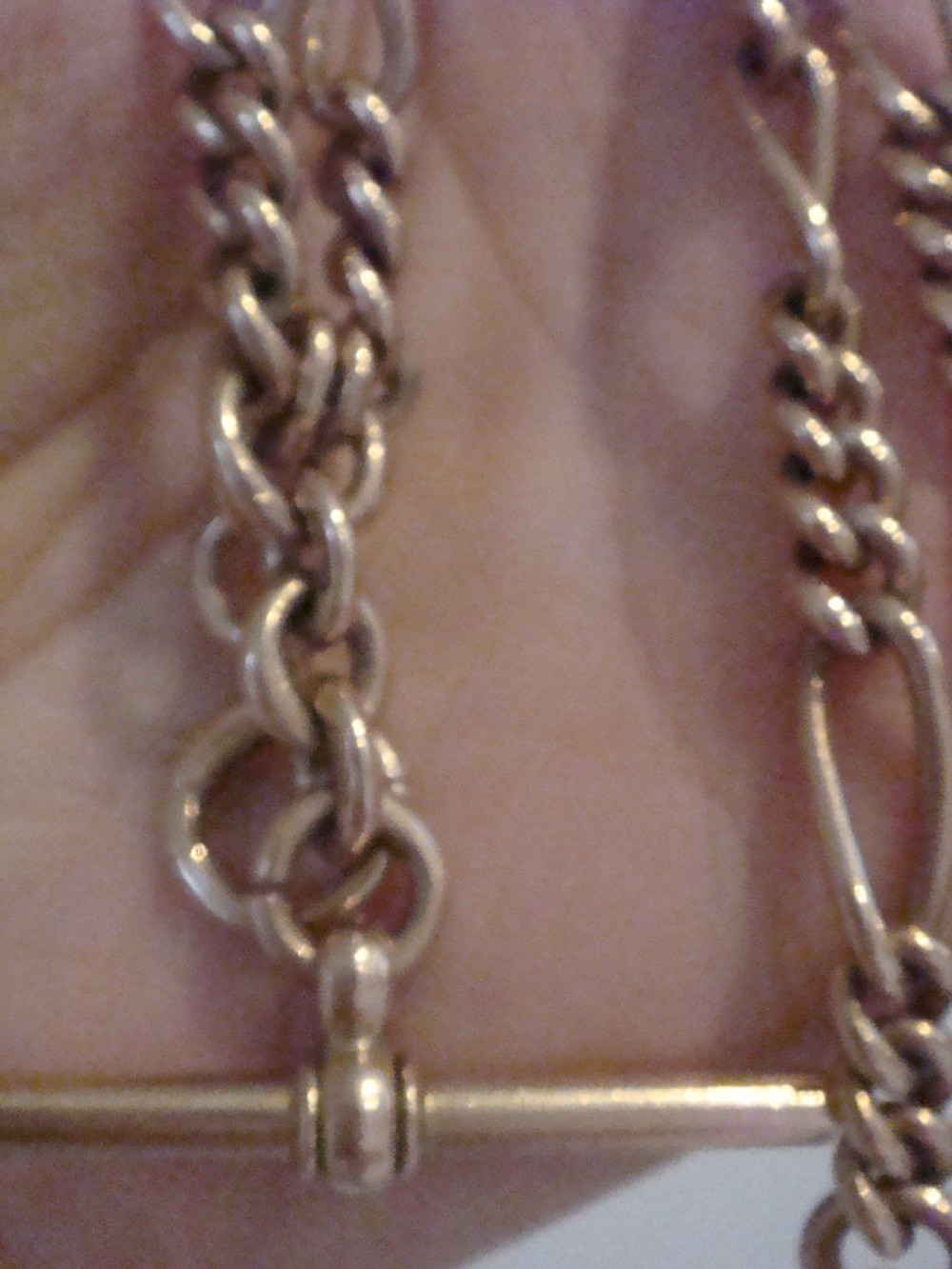 An Edwardian 9ct yellow gold Figaro link double Albert chain featuring a central T-bar, floating ring, and two dog clip fasteners. View VI