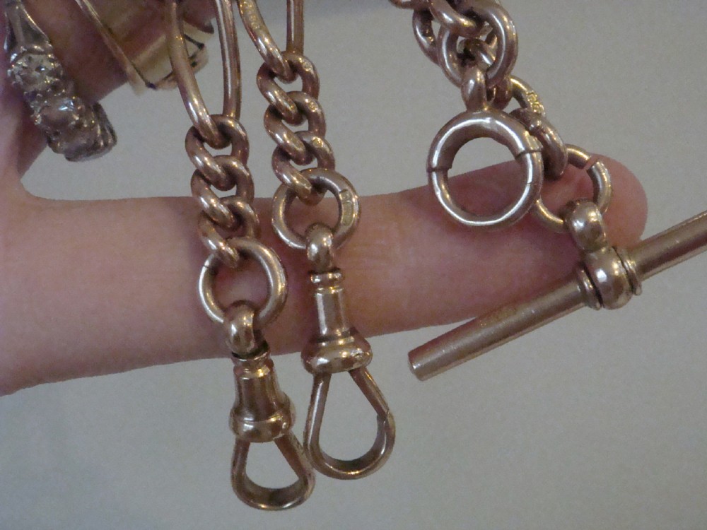 An Edwardian 9ct yellow gold Figaro link double Albert chain featuring a central T-bar, floating ring, and two dog clip fasteners. View X