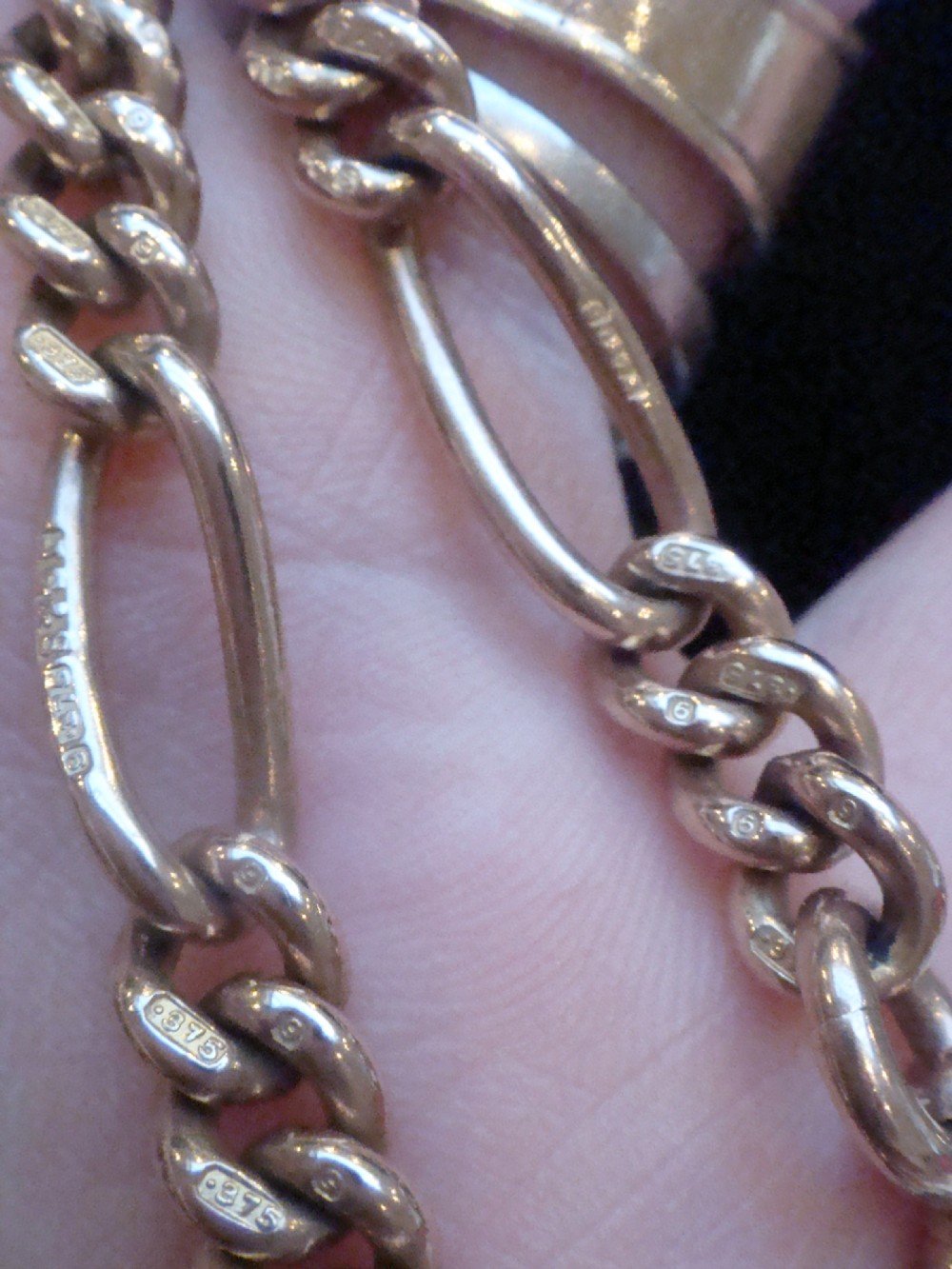 An Edwardian 9ct yellow gold Figaro link double Albert chain featuring a central T-bar, floating ring, and two dog clip fasteners. View XI