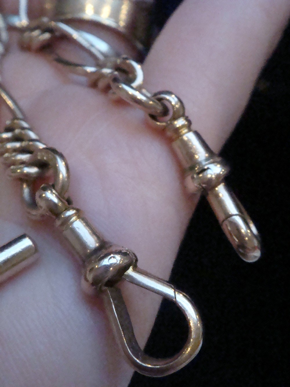 An Edwardian 9ct yellow gold Figaro link double Albert chain featuring a central T-bar, floating ring, and two dog clip fasteners. View XII