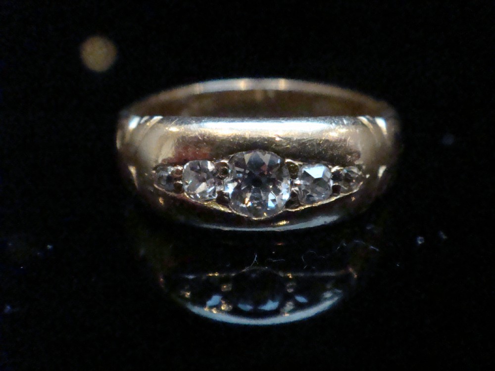 An Edwardian 18ct yellow gold band ring featuring flush-set old cut diamonds along the centre. View IV