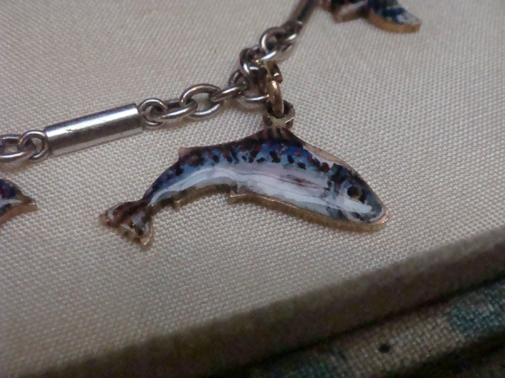 An Edwardian gold link chain bracelet featuring polychrome enamelled wildlife charms including game birds and a fish. View V