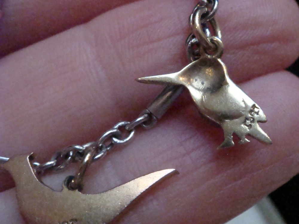 An Edwardian gold link chain bracelet featuring polychrome enamelled wildlife charms including game birds and a fish. View VIII
