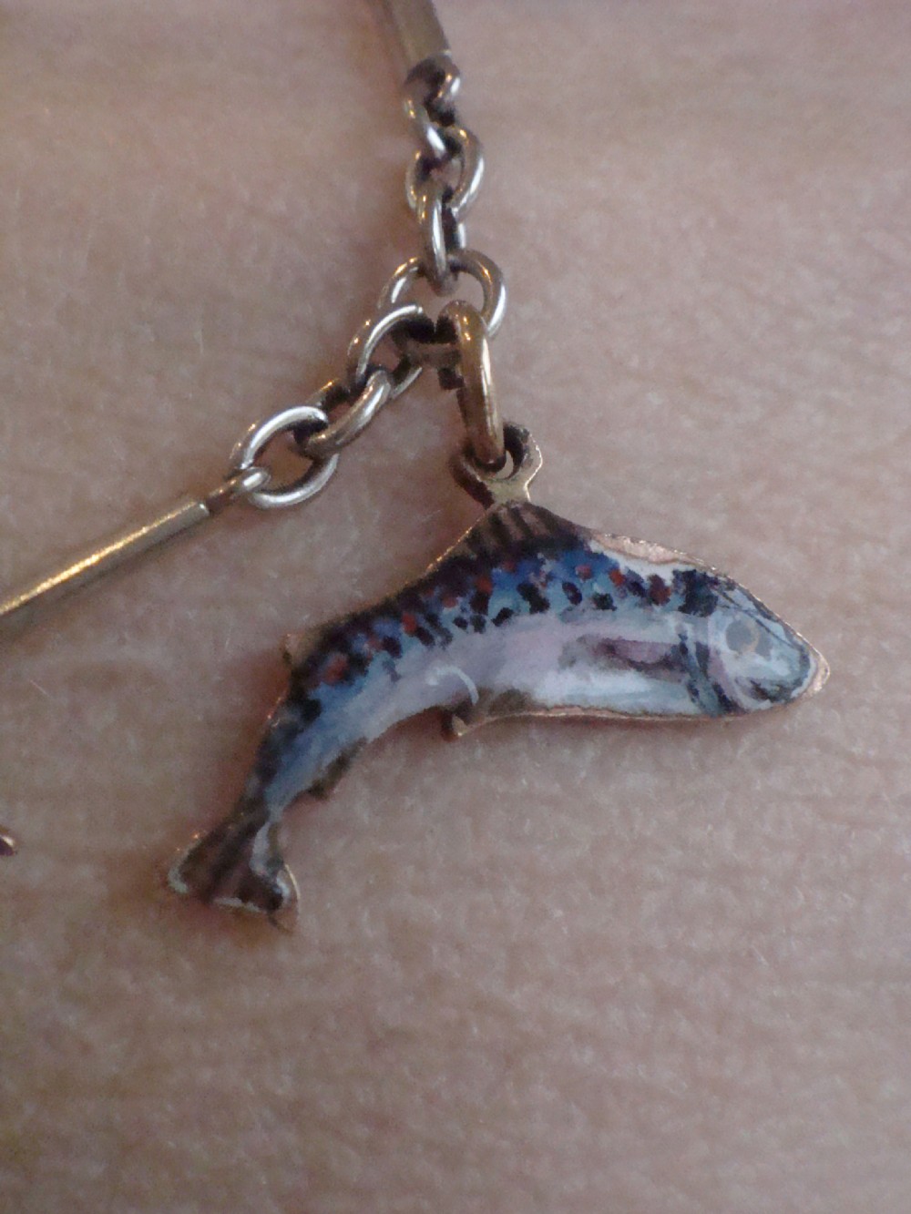 An Edwardian gold link chain bracelet featuring polychrome enamelled wildlife charms including game birds and a fish. View XIII
