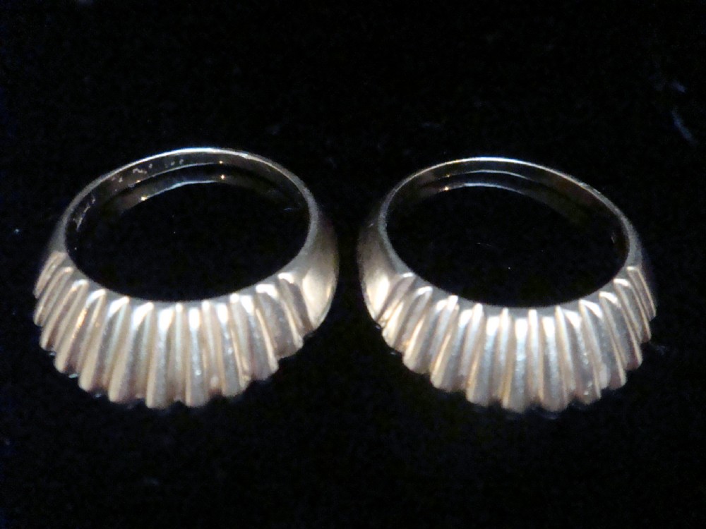 A pair of 9ct yellow gold ring enhancers featuring a fluted and ribbed texture designed to frame a central band.