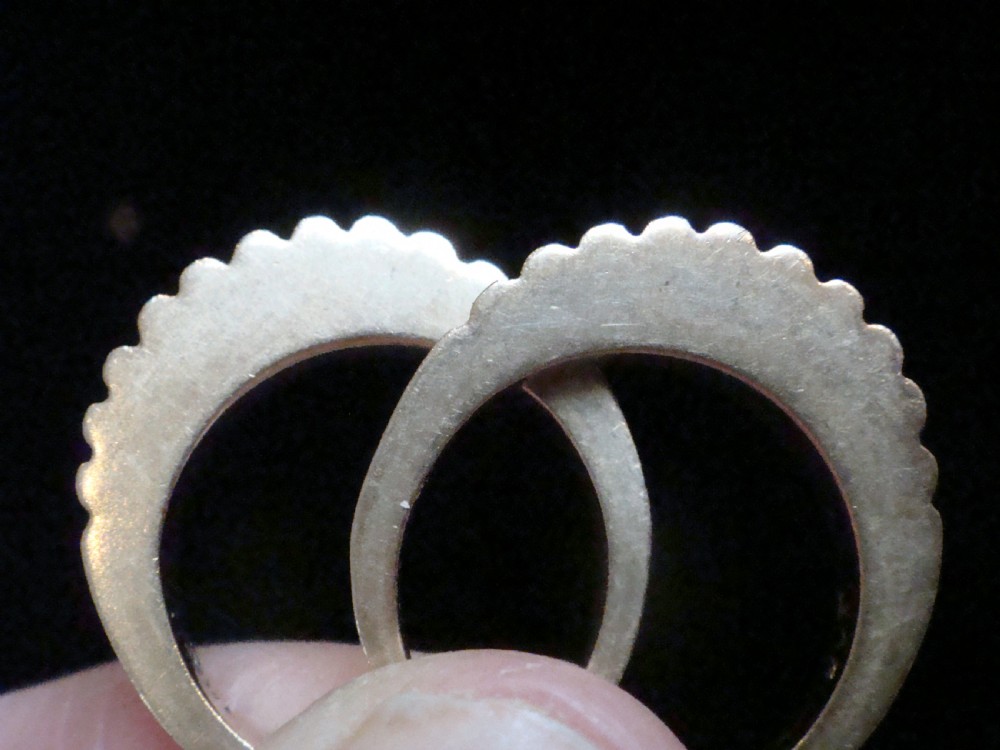 A pair of 9ct yellow gold ring enhancers featuring a fluted and ribbed texture designed to frame a central band. View II