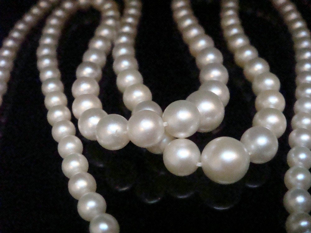 A double strand graduated white cultured pearl necklace featuring an ornate silver box clasp set with a single pearl. View III